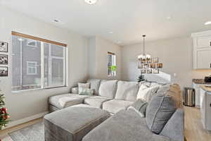 Living room featuring light hardwood / wood-style flooring and a chandelier