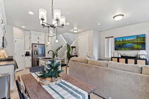 Dining space with light wood-type flooring, stairway, a notable chandelier, and recessed lighting