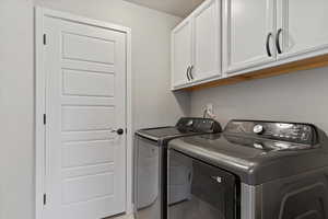 Laundry area with cabinets and washing machine and clothes dryer