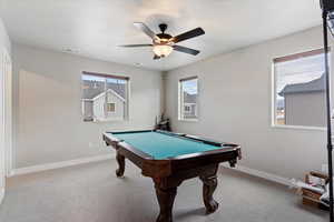 Rec room featuring light colored carpet, ceiling fan, a healthy amount of sunlight, and billiards