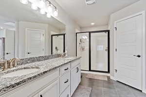 Bathroom with tile patterned flooring, vanity, and a shower with shower door