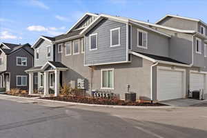 View of front facade with a garage and central AC