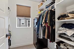 Walk in closet featuring light colored carpet