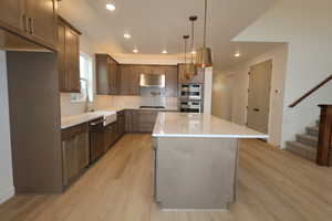 Kitchen featuring pendant lighting, sink, appliances with stainless steel finishes, a center island, and tasteful backsplash