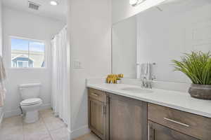 Bathroom with tile patterned floors, vanity, and toilet