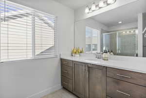 Bathroom with tile patterned flooring, vanity, and walk in shower