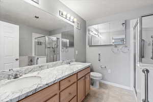 En suite bathroom featuring vanity, toilet, walk in shower, and soaking tub.  Grab bars installed for safety.