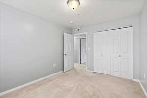 3rd bedroom with a closet, fresh paint,  light colored carpet and natural light