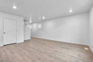 Basement with light wood-type flooring