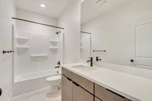 Full bathroom featuring shower / bath combination, vanity, tile patterned flooring, and toilet