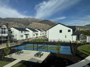 View of sport court featuring a mountain view and tennis court