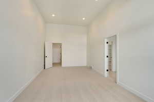 Spare room with light carpet, visible vents, baseboards, a high ceiling, and recessed lighting