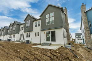 Back of house with cooling unit and a patio