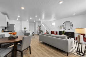 Living room featuring light hardwood / wood-style flooring, a textured ceiling, and sink