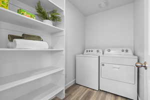 Laundry area featuring light wood-type flooring and separate washer and dryer