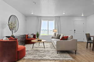 Living room with light wood-type flooring and a textured ceiling