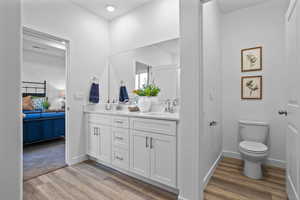 Bathroom featuring hardwood / wood-style floors, vanity, and toilet