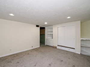 Unfurnished bedroom with carpet flooring, a closet, and a textured ceiling