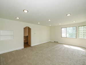 Spare room featuring carpet flooring and built in shelves