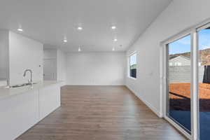 Interior space with white cabinets, sink, and light hardwood / wood-style flooring