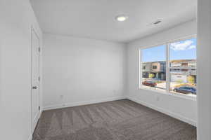 Empty room featuring carpet and a textured ceiling