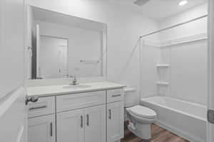 Full bathroom with shower / bathing tub combination, vanity, wood-type flooring, and toilet