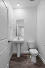 Bathroom with hardwood / wood-style flooring and toilet