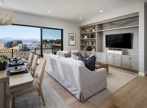 Living room with a mountain view, light hardwood / wood-style floors, built in shelves, and an inviting chandelier