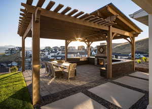 View of patio with a mountain view, a pergola, and exterior fireplace