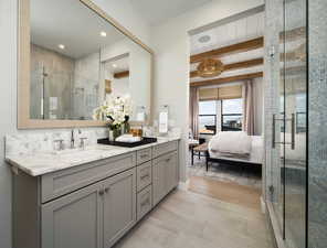 Bathroom featuring beamed ceiling, vanity, and a shower with door