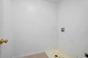 Washroom featuring light tile patterned floors and hookup for a washing machine