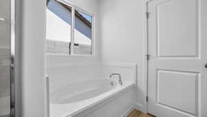 Bathroom featuring hardwood / wood-style floors and a bath