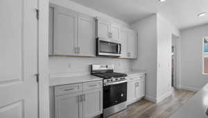 Kitchen with a textured ceiling, stainless steel appliances, and dark hardwood / wood-style floors