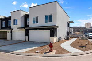 View of front of home featuring a garage and cooling unit