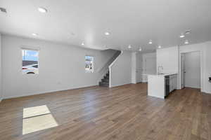 Unfurnished living room with a textured ceiling, dark hardwood / wood-style flooring, and sink