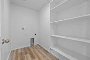 Laundry room featuring electric dryer hookup, hardwood / wood-style floors, and washer hookup