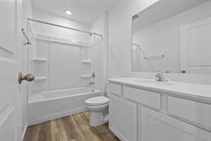 Full bathroom with vanity, wood-type flooring,  shower combination, and toilet