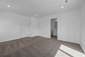 Empty room featuring dark colored carpet