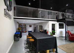 Interior space with stainless steel fridge and a towering ceiling