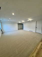 Basement with a textured ceiling and hardwood / wood-style flooring