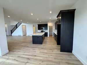 Kitchen featuring a kitchen island with sink and light hardwood / wood-style flooring