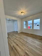 Spare room with light hardwood / wood-style floors and a textured ceiling