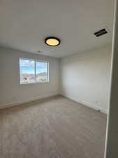 Carpeted spare room featuring a textured ceiling