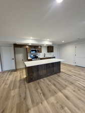 Kitchen featuring a kitchen island, sink, appliances with stainless steel finishes, and light hardwood / wood-style flooring