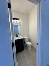 Bathroom with vanity, a textured ceiling, and toilet