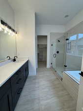 Bathroom with vanity, an enclosed shower, and a textured ceiling