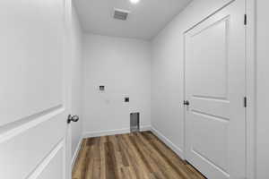 Clothes washing area featuring hookup for an electric dryer, washer hookup, and dark hardwood / wood-style floors