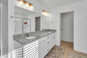 Bathroom with tile patterned flooring, vanity, and an enclosed shower