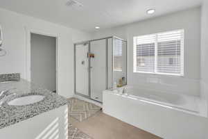 Bathroom with tile patterned flooring, vanity, and separate shower and tub