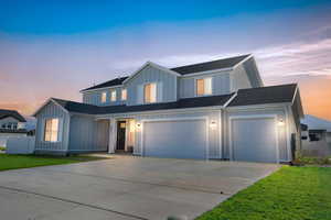 View of front of house with a yard and a garage